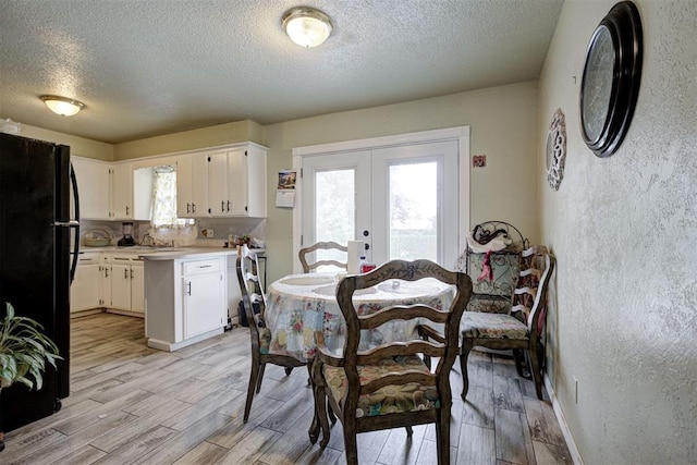 3117 Lazy Ln, Del City, OK 73115 - dining space featuring french doors, a textured ceiling, wood tiled floors, and a textured wall