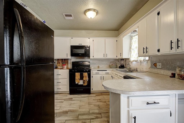 3117 Lazy Ln, Del City, OK 73115 - kitchen featuring black appliances, a sink, light countertops, a textured ceiling, and a peninsula