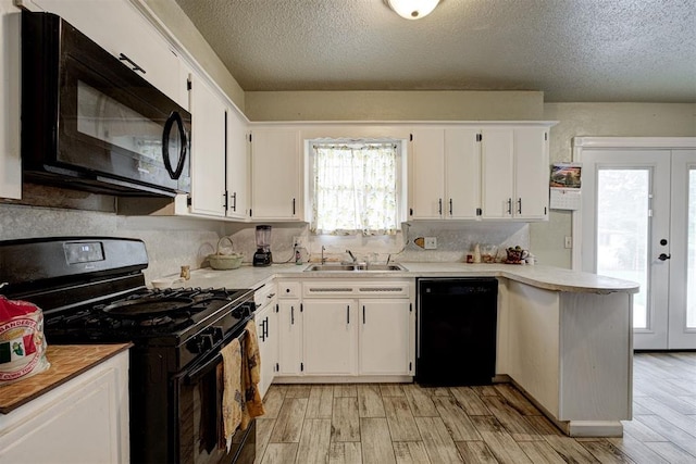 3117 Lazy Ln, Del City, OK 73115 - kitchen featuring black appliances, a sink, light wood finished floors, light countertops, and white cabinets