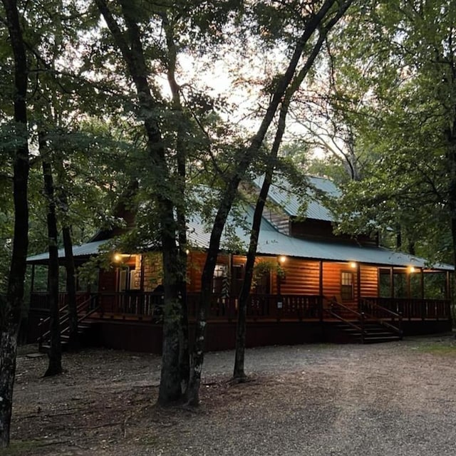 173 Alexis Ln, Broken Bow, OK 74728 - rear view of house featuring log veneer siding, a wooden deck, and metal roof