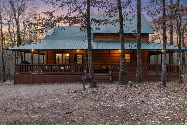 173 Alexis Ln, Broken Bow, OK 74728 - view of front facade featuring log veneer siding, covered porch, and metal roof