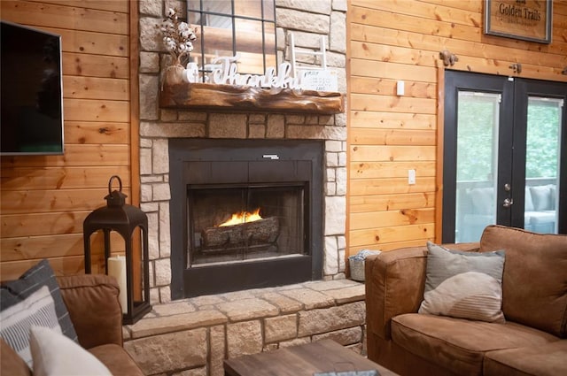 173 Alexis Ln, Broken Bow, OK 74728 - living room featuring wood walls, a stone fireplace, and french doors