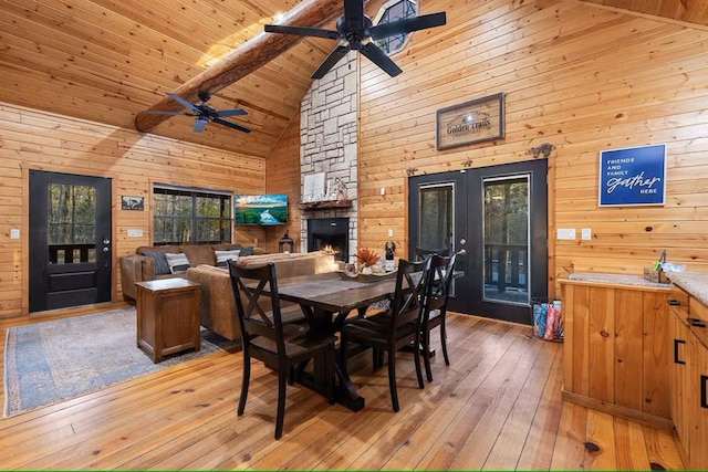 173 Alexis Ln, Broken Bow, OK 74728 - dining area featuring high vaulted ceiling, a ceiling fan, french doors, light wood-style flooring, and a stone fireplace