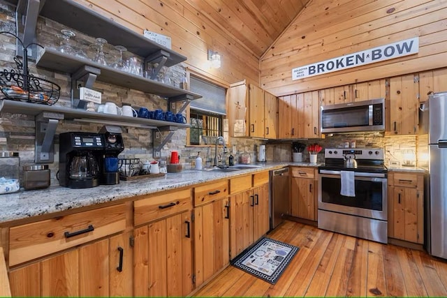 173 Alexis Ln, Broken Bow, OK 74728 - kitchen with appliances with stainless steel finishes, a sink, lofted ceiling, backsplash, and light wood-style floors