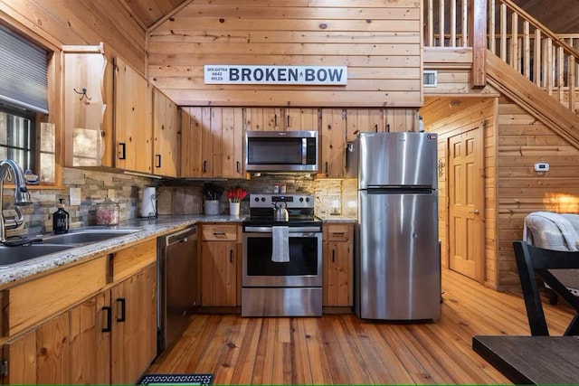 173 Alexis Ln, Broken Bow, OK 74728 - kitchen featuring stainless steel appliances, a sink, decorative backsplash, light wood-style flooring, and vaulted ceiling