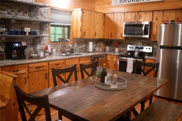 173 Alexis Ln, Broken Bow, OK 74728 - kitchen featuring stainless steel appliances, a sink, tasteful backsplash, light countertops, and wood finished floors