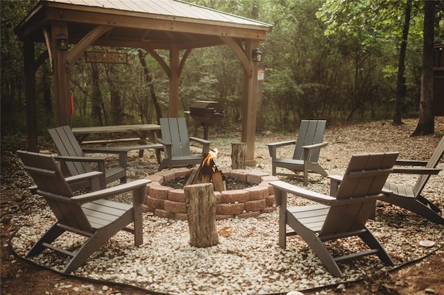173 Alexis Ln, Broken Bow, OK 74728 - view of patio / terrace featuring a fire pit, a gazebo, and a wooded view