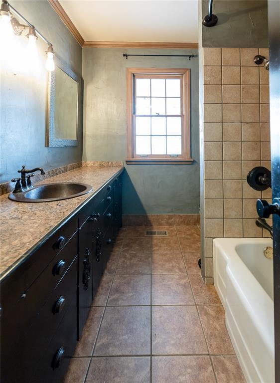 1301 W C Ave, Elk City, OK 73644 - bathroom with crown molding, vanity, tile patterned flooring, shower / bath combination, and baseboards