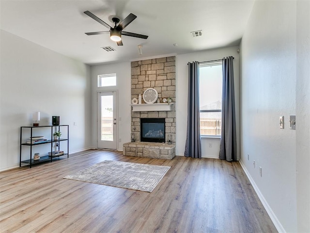 16020 Panther Way, Edmond, OK 73013 - living room featuring a ceiling fan, wood finished floors, a stone fireplace, and baseboards