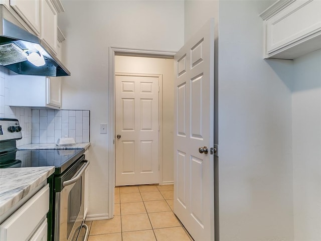 16020 Panther Way, Edmond, OK 73013 - kitchen with electric stove, exhaust hood, white cabinetry, light tile patterned floors, and backsplash