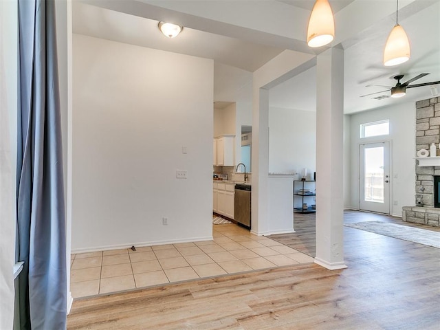 16020 Panther Way, Edmond, OK 73013 - empty room featuring ceiling fan, light wood-type flooring, a fireplace, a sink, and baseboards
