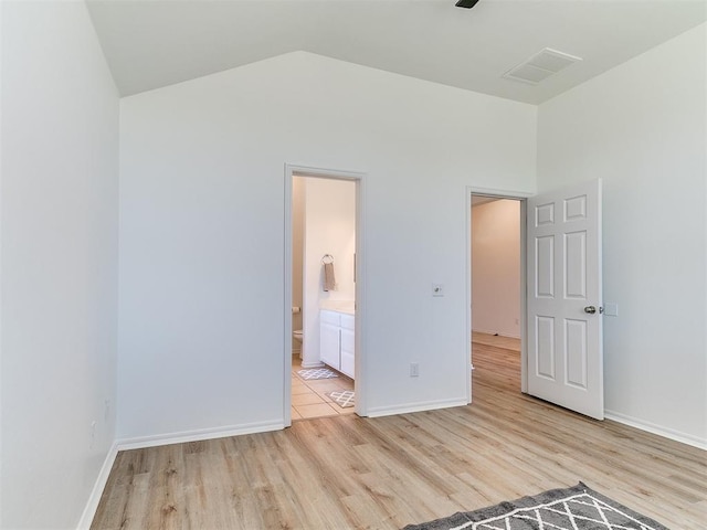 16020 Panther Way, Edmond, OK 73013 - unfurnished bedroom with light wood finished floors, lofted ceiling, and baseboards