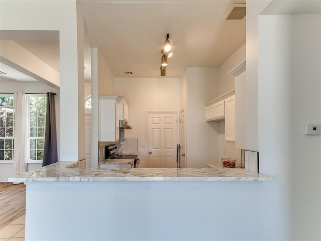 16020 Panther Way, Edmond, OK 73013 - kitchen featuring electric range, decorative backsplash, light stone counters, white cabinets, and a peninsula