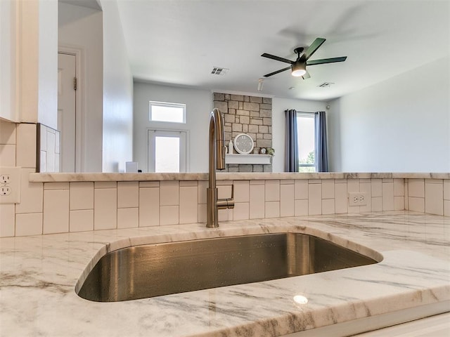 16020 Panther Way, Edmond, OK 73013 - kitchen view of a sink, decorative backsplash, ceiling fan, and light stone counters