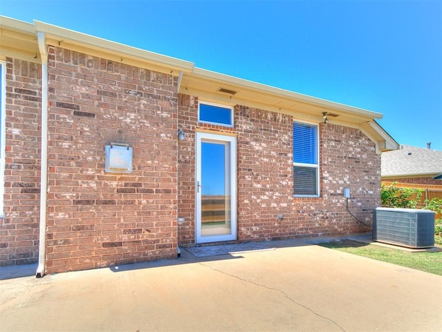 16020 Panther Way, Edmond, OK 73013 - rear view of house with a patio area, central AC, and brick siding