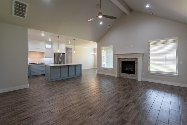 14601 Chambord Dr, Yukon, OK 73099 - unfurnished living room featuring beam ceiling, a ceiling fan, dark wood-style floors, high vaulted ceiling, and baseboards