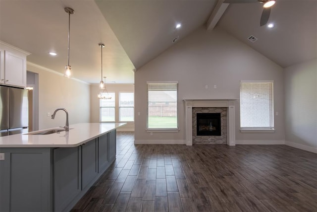 14601 Chambord Dr, Yukon, OK 73099 - kitchen featuring open floor plan, a sink, freestanding refrigerator, beamed ceiling, and an island with sink