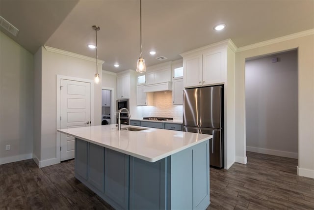 14601 Chambord Dr, Yukon, OK 73099 - kitchen featuring appliances with stainless steel finishes, ornamental molding, baseboards, a center island with sink, and a sink