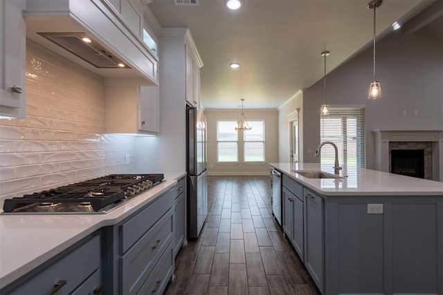 14601 Chambord Dr, Yukon, OK 73099 - kitchen featuring a sink, appliances with stainless steel finishes, light countertops, custom exhaust hood, and decorative backsplash