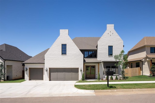 3817 Shady Hill Trl, Edmond, OK 73034 - view of front of home featuring a chimney, french doors, an attached garage, and driveway