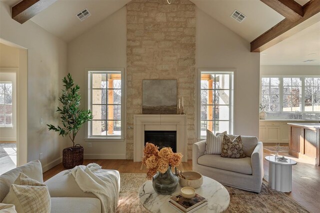 3817 Shady Hill Trl, Edmond, OK 73034 - living area with wood finished floors, healthy amount of natural light, beam ceiling, a fireplace, and high vaulted ceiling