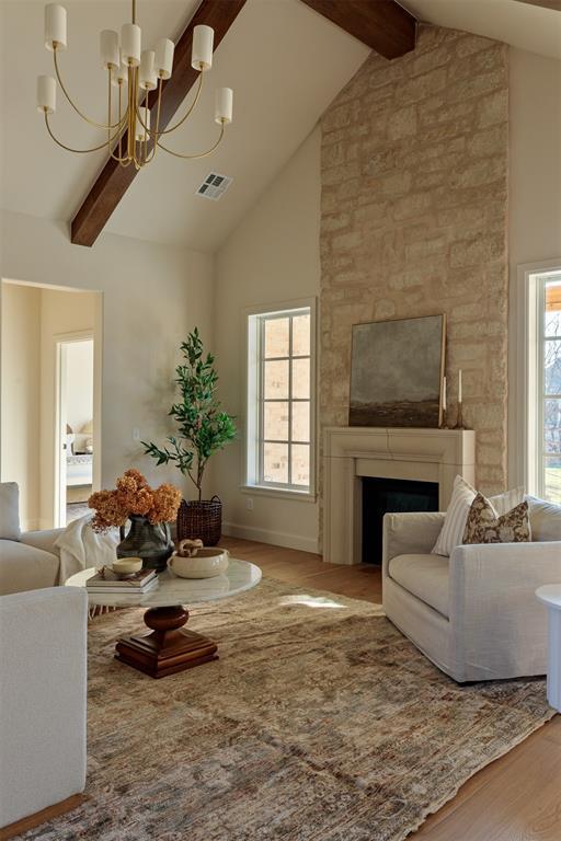 3817 Shady Hill Trl, Edmond, OK 73034 - living room with a chandelier, wood finished floors, beamed ceiling, high vaulted ceiling, and a fireplace