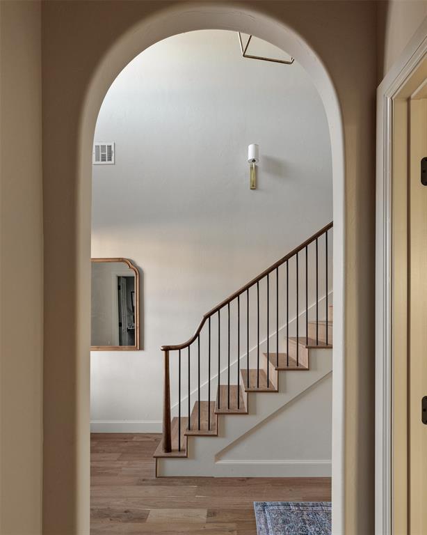3817 Shady Hill Trl, Edmond, OK 73034 - stairway with arched walkways, wood finished floors, and baseboards