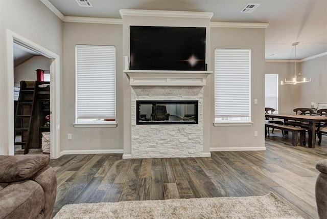 715 SE 37th St, Newcastle, OK 73065 - living room featuring wood finished floors, a chandelier, baseboards, crown molding, and a stone fireplace