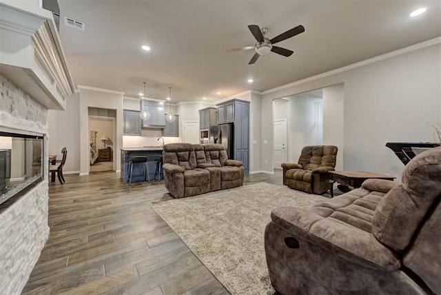 715 SE 37th St, Newcastle, OK 73065 - living room featuring ornamental molding, ceiling fan, wood finished floors, recessed lighting, and a fireplace