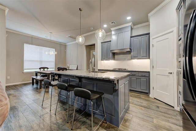 715 SE 37th St, Newcastle, OK 73065 - kitchen with gray cabinets, a sink, premium range hood, ornamental molding, and a center island with sink
