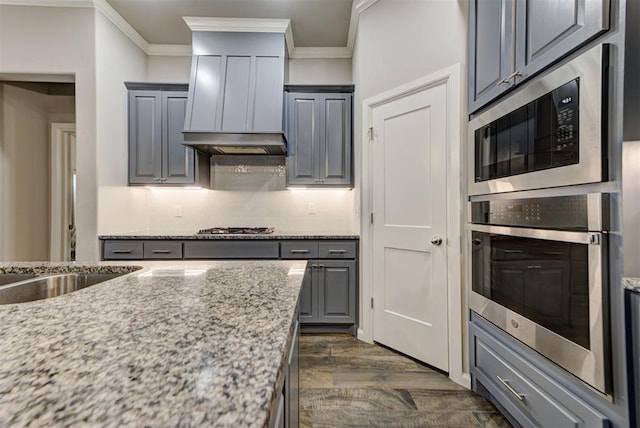 715 SE 37th St, Newcastle, OK 73065 - kitchen featuring stainless steel appliances, ornamental molding, dark wood finished floors, decorative backsplash, and gray cabinetry