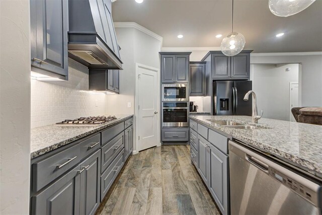 715 SE 37th St, Newcastle, OK 73065 - kitchen featuring stainless steel appliances, a sink, custom range hood, crown molding, and light stone counters