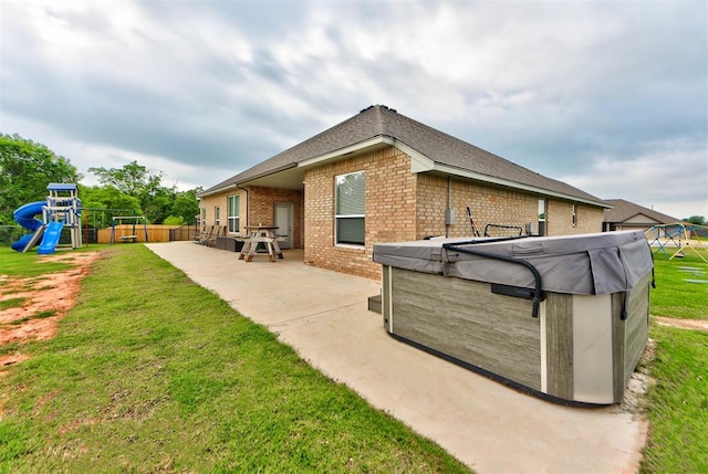 715 SE 37th St, Newcastle, OK 73065 - back of house featuring brick siding, a playground, a patio area, and a hot tub