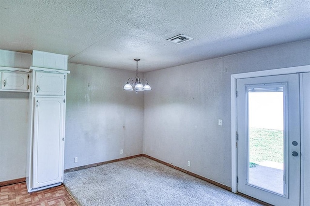 1110 Lollar Dr, Maysville, OK 73057 - unfurnished dining area with a chandelier, a textured ceiling, and baseboards
