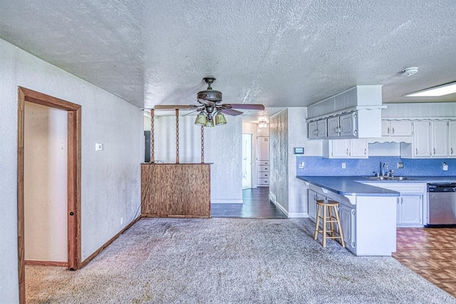 1110 Lollar Dr, Maysville, OK 73057 - kitchen featuring stainless steel dishwasher, a sink, a ceiling fan, white cabinetry, and a textured ceiling