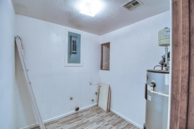 1110 Lollar Dr, Maysville, OK 73057 - laundry area featuring water heater, light wood finished floors, a textured ceiling, electric dryer hookup, and baseboards