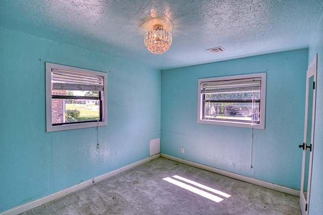 1110 Lollar Dr, Maysville, OK 73057 - carpeted empty room featuring baseboards, a textured ceiling, and a chandelier