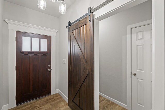 2382 County Road 1262, Blanchard, OK 73010 - foyer entrance with a barn door, light wood finished floors, and baseboards