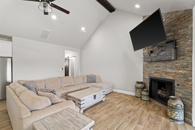 2382 County Road 1262, Blanchard, OK 73010 - living room with a ceiling fan, beamed ceiling, a barn door, a fireplace, and baseboards