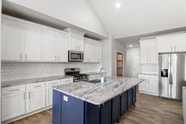 2382 County Road 1262, Blanchard, OK 73010 - kitchen with appliances with stainless steel finishes, blue cabinetry, tasteful backsplash, wood finished floors, and white cabinetry