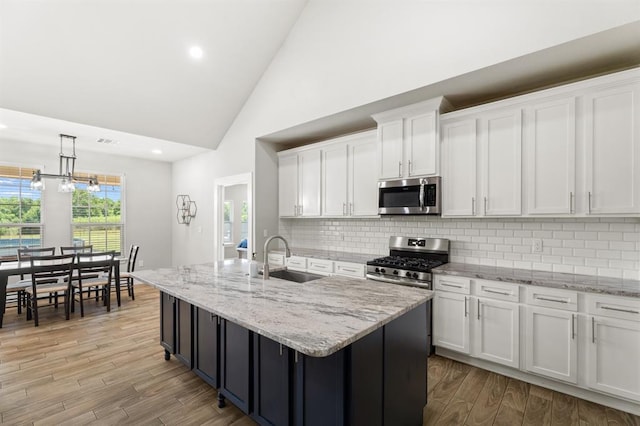 2382 County Road 1262, Blanchard, OK 73010 - kitchen featuring appliances with stainless steel finishes, a sink, white cabinetry, high vaulted ceiling, and backsplash