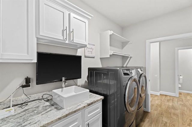2382 County Road 1262, Blanchard, OK 73010 - laundry room featuring washer and dryer, light wood-style floors, cabinet space, and baseboards