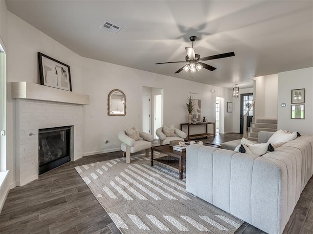 2257 Preserve Edge Dr, Edmond, OK 73034 - living room with dark wood-style floors, a fireplace, stairway, a ceiling fan, and baseboards