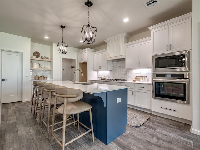 2257 Preserve Edge Dr, Edmond, OK 73034 - kitchen featuring appliances with stainless steel finishes, open shelves, a sink, recessed lighting, and a kitchen island with sink