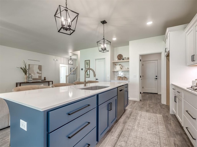 2257 Preserve Edge Dr, Edmond, OK 73034 - kitchen with a sink, blue cabinets, dishwasher, white cabinetry, and open shelves