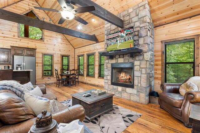 186 W Eagle Mountain Trl, Broken Bow, OK 74728 - living room with wooden walls, high vaulted ceiling, light wood-type flooring, a wooden ceiling with exposed beams, and a stone fireplace