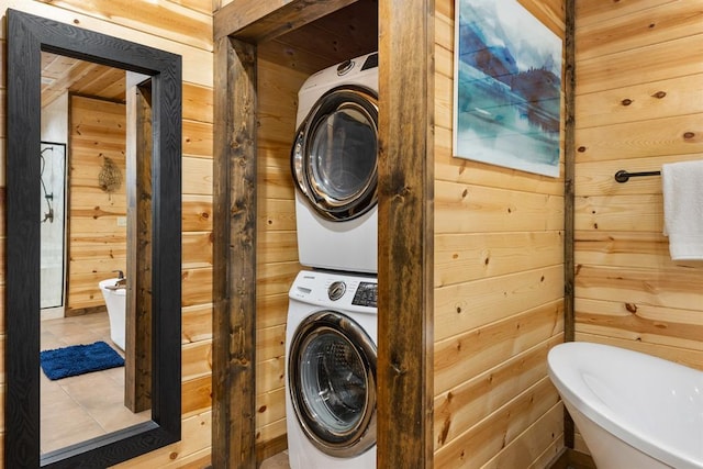 186 W Eagle Mountain Trl, Broken Bow, OK 74728 - laundry area featuring stacked washing machine and dryer, wooden walls, and tile patterned flooring