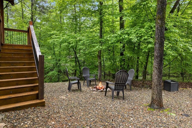 186 W Eagle Mountain Trl, Broken Bow, OK 74728 - view of yard with stairs, a fire pit, and a forest view