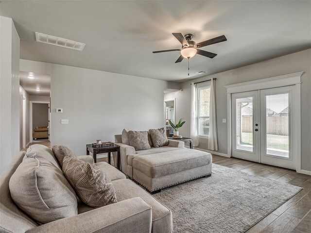 11052 NW 21st St, Yukon, OK 73099 - living room with french doors, wood finished floors, ceiling fan, and baseboards