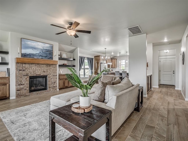 11052 NW 21st St, Yukon, OK 73099 - living room featuring ceiling fan, a brick fireplace, wood finished floors, and baseboards